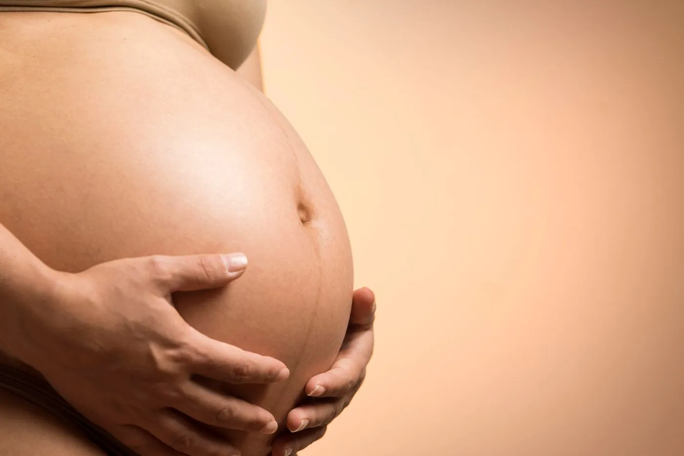 Manos de una mujer embarazada sobre su vientre